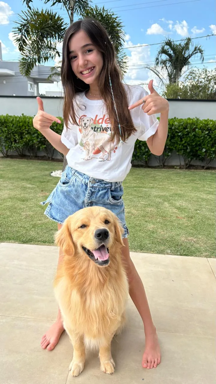 Menina com Golden Retriever apontando para a estampa PattaMansa